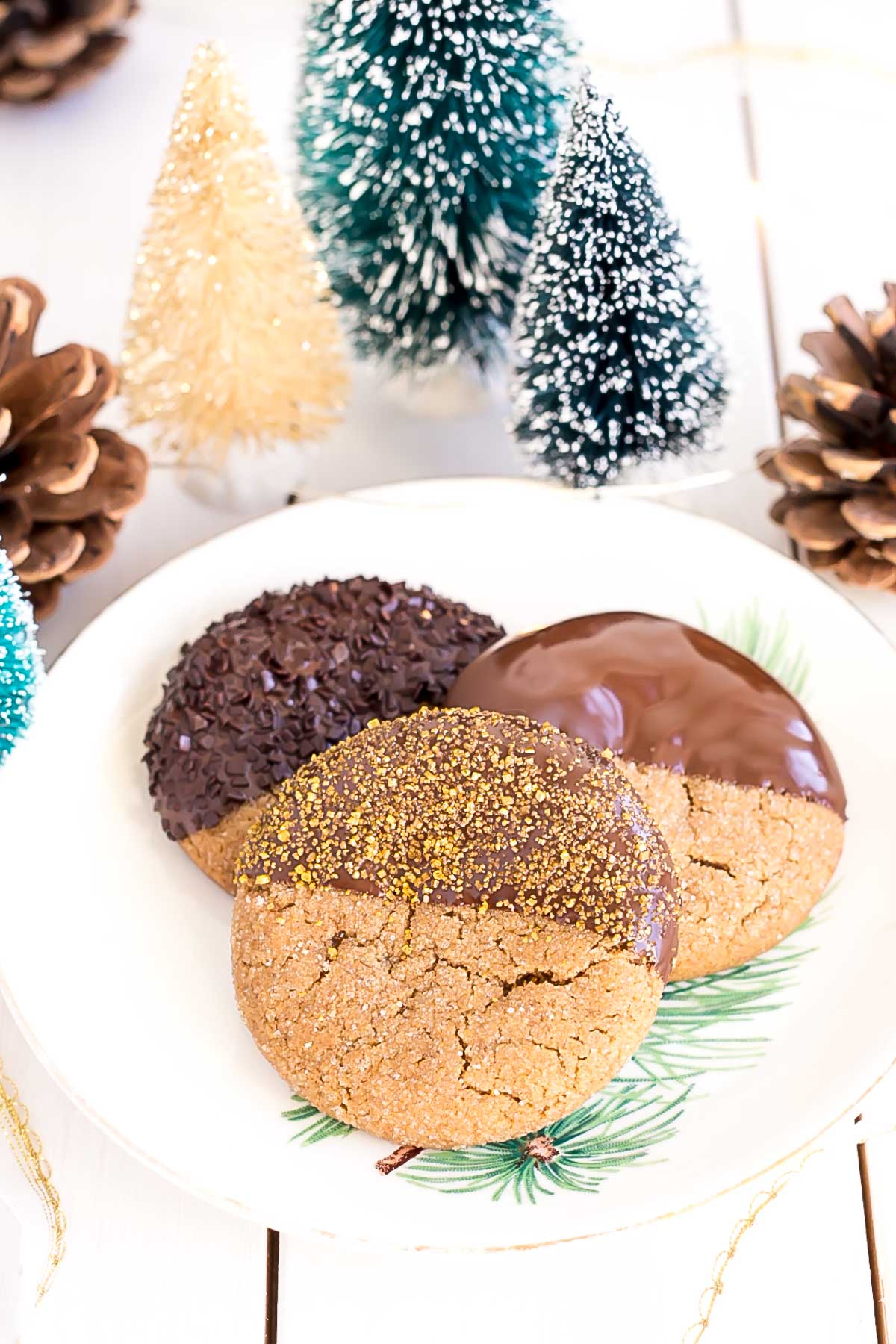 These Chocolate Dipped Gingerbread Cookies are the perfect treat for the holiday season! Chewy ginger spiced cookies dipped in dark chocolate. | livforcake.com Three cookies on a plate