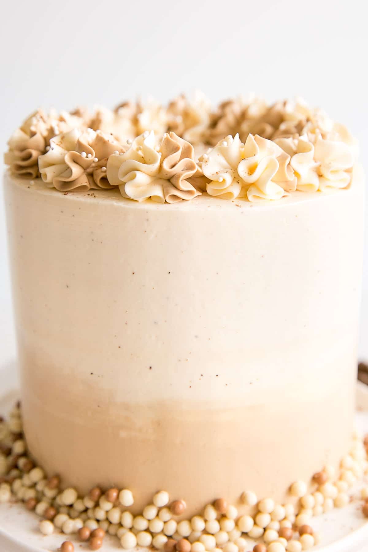 Eggnog Latte Cake! Transform a favourite holiday beverage into a decadent dessert with this Eggnog Latte Cake! Eggnog infused cake layers paired with eggnog and espresso buttercreams. | livforcake.com Close up of the cake showing the frosting and rosettes.