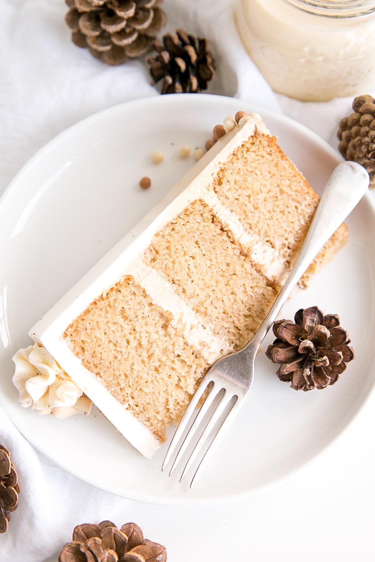 Eggnog Latte Cake! Transform a favourite holiday beverage into a decadent dessert with this Eggnog Latte Cake! Eggnog infused cake layers paired with eggnog and espresso buttercreams. | livforcake.com Slice of eggnog latte cake on a plate.