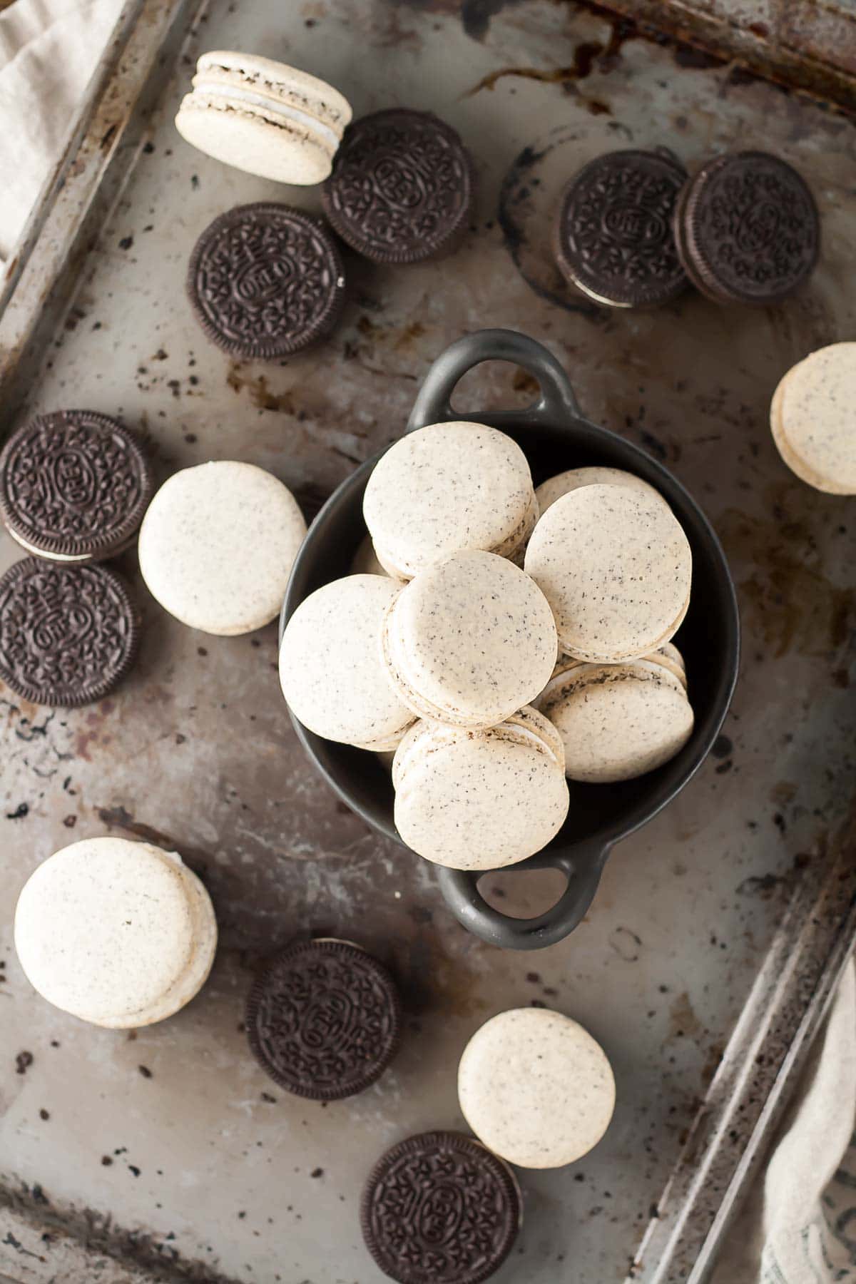 Oreo Macarons! Turn your favourite store-bought classics into something more decadent with these delicate Oreo macarons. | livforcake.com Overhead image of oreo macarons on a baking sheet.