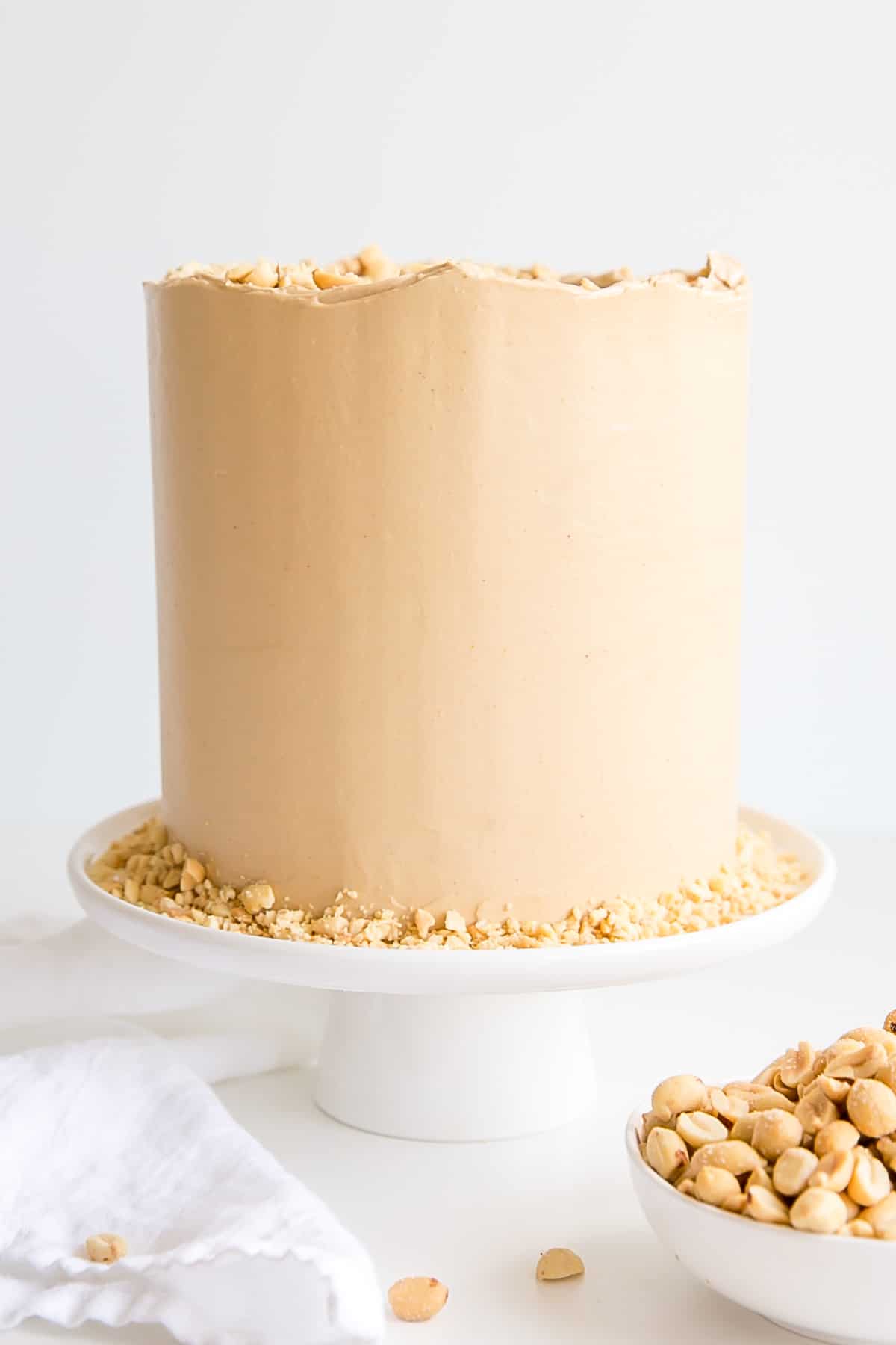 Peanut butter lovers, this cake is for you! Peanut butter cake layers studded with peanut butter chips covered in a peanut butter Swiss meringue buttercream. | livforcake.com Close up of the buttercream on the sides.