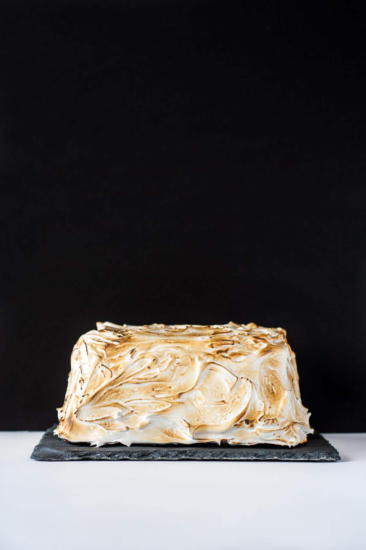 Far away shot of the cake on a black background.